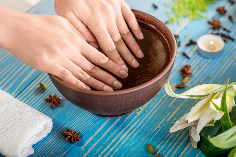 Ngâm tay với nước muối loãng giúp giảm vết chai tay
